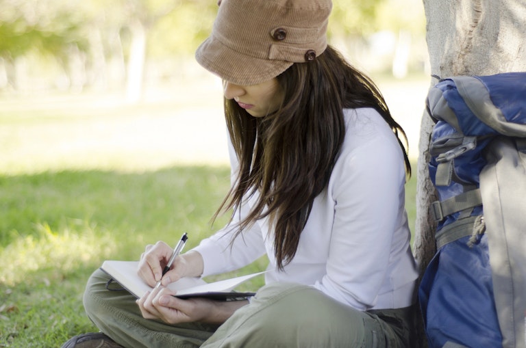 Young woman writing in a journal
